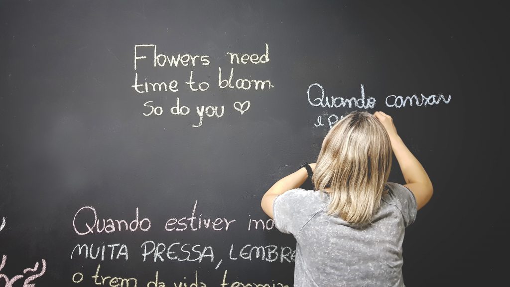 A kid writing on a black board