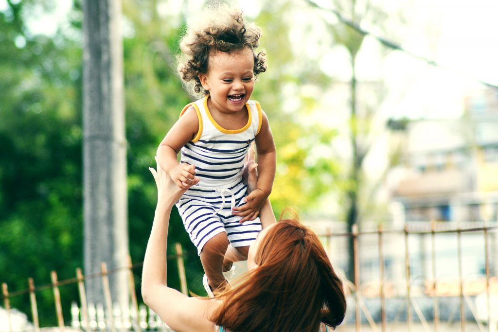 women playing and throwing a child in the air